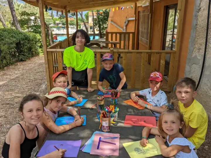 Enfants dessinant ensemble en plein air.