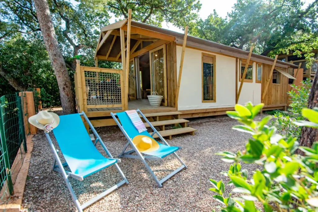 Chalet en bois avec transats bleus et terrasse.
